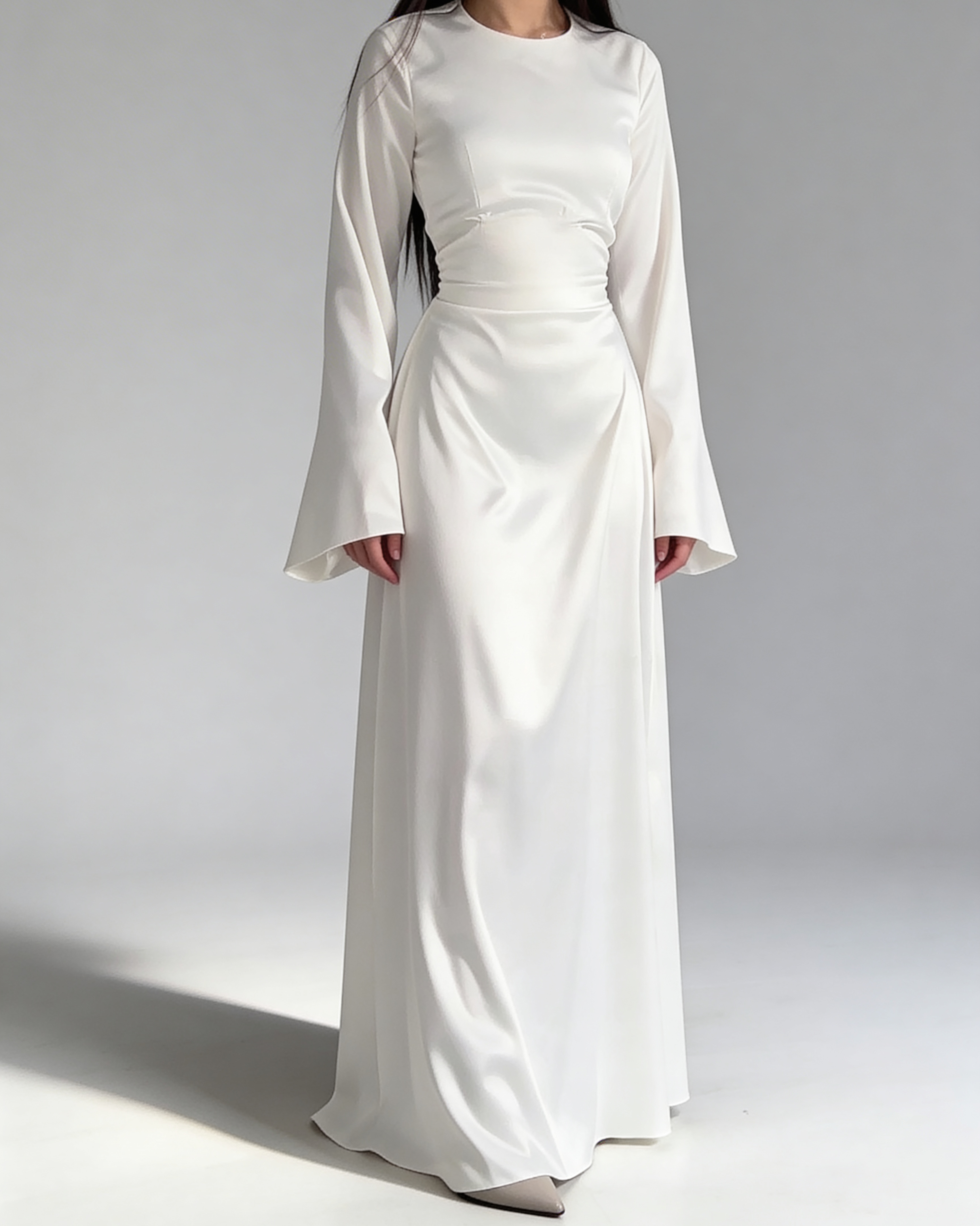 Femme portant la robe longue fluide en satin blanc, style chic et minimaliste.