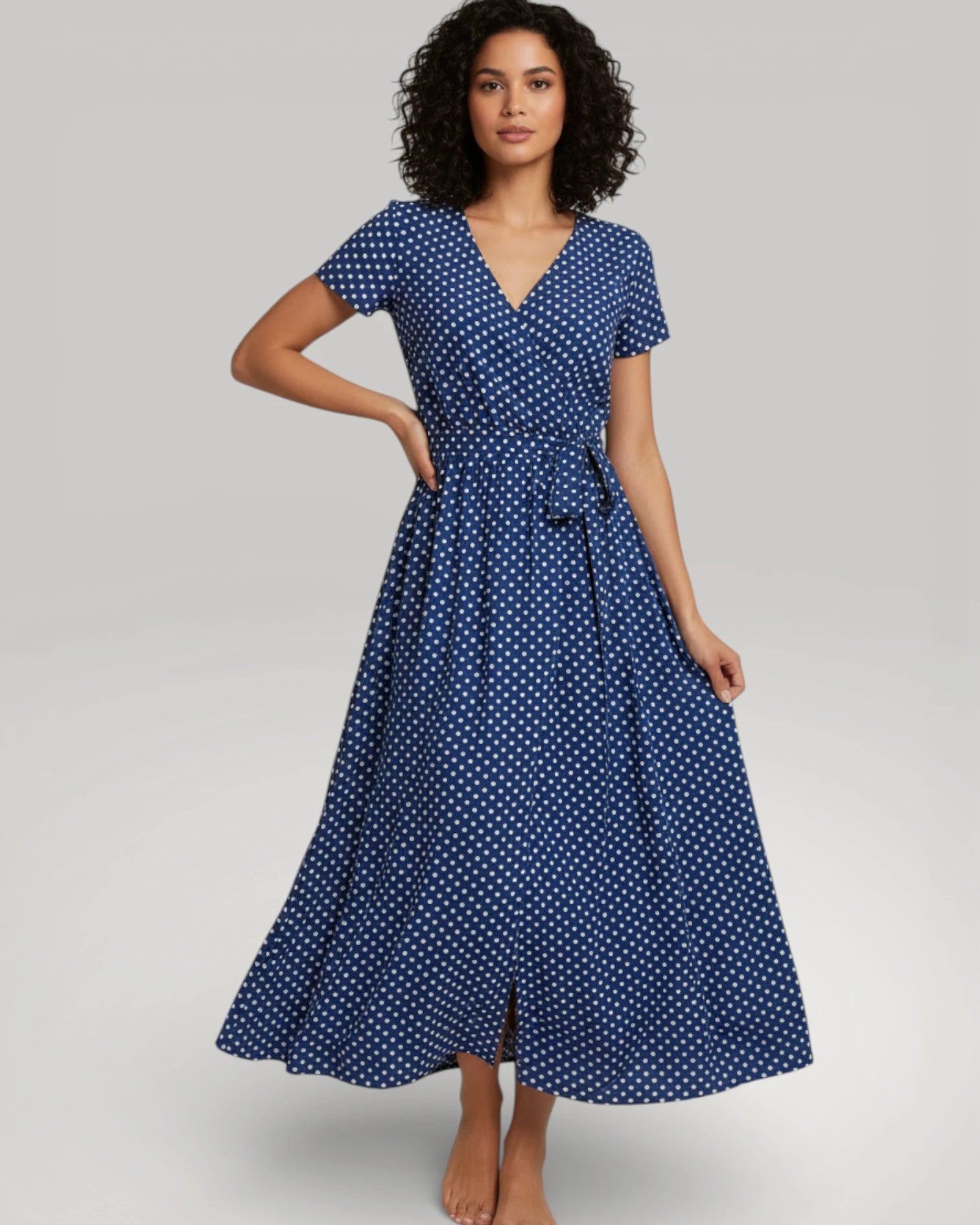 Robe longue d'été portefeuille pour femme de couleur bleue à pois blancs, portée par un mannequin - Modèle Julie par Urbain Couture.