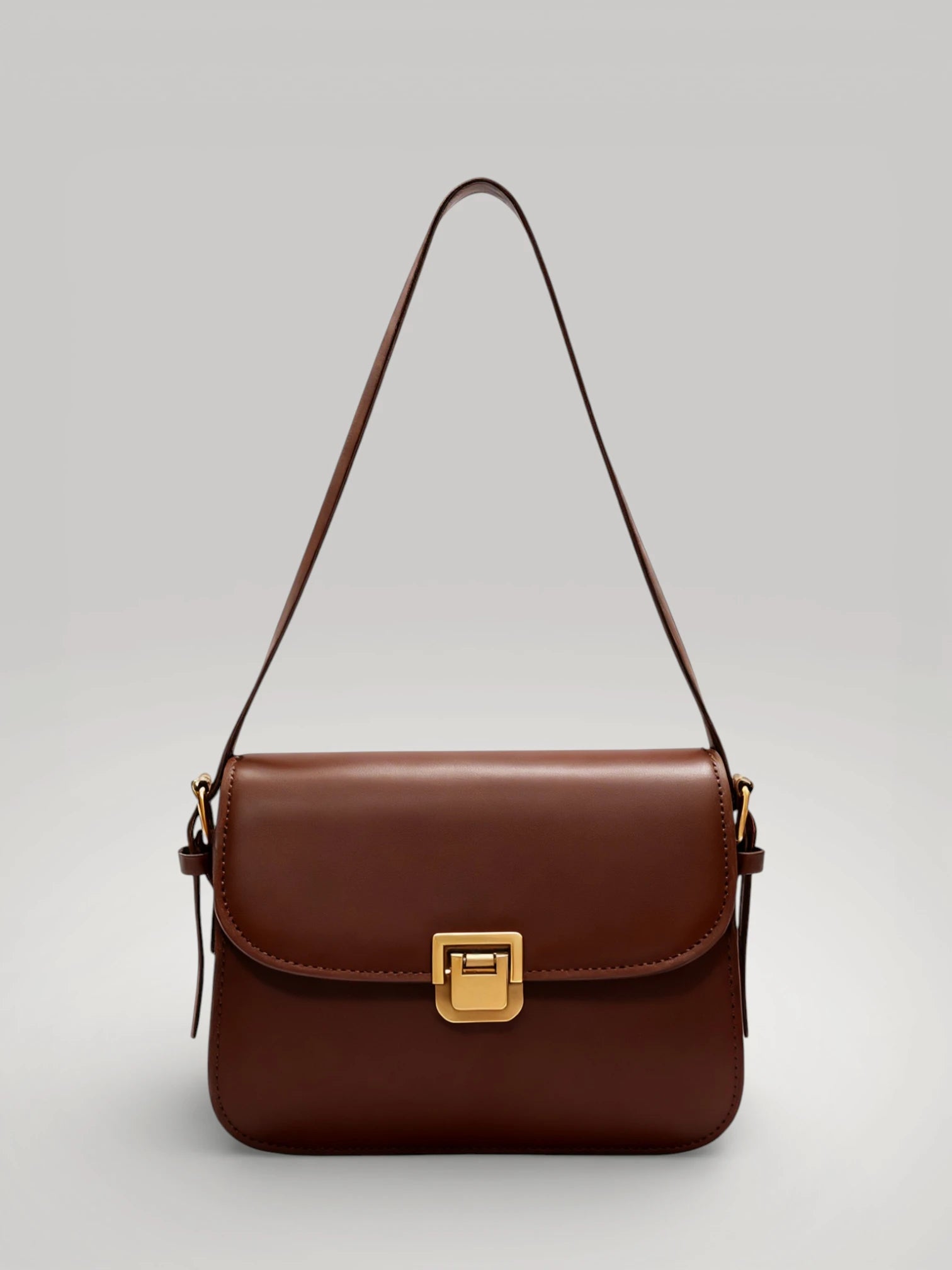 Sac à main carré noir en cuir synthétique avec fermoir doré de luxe.