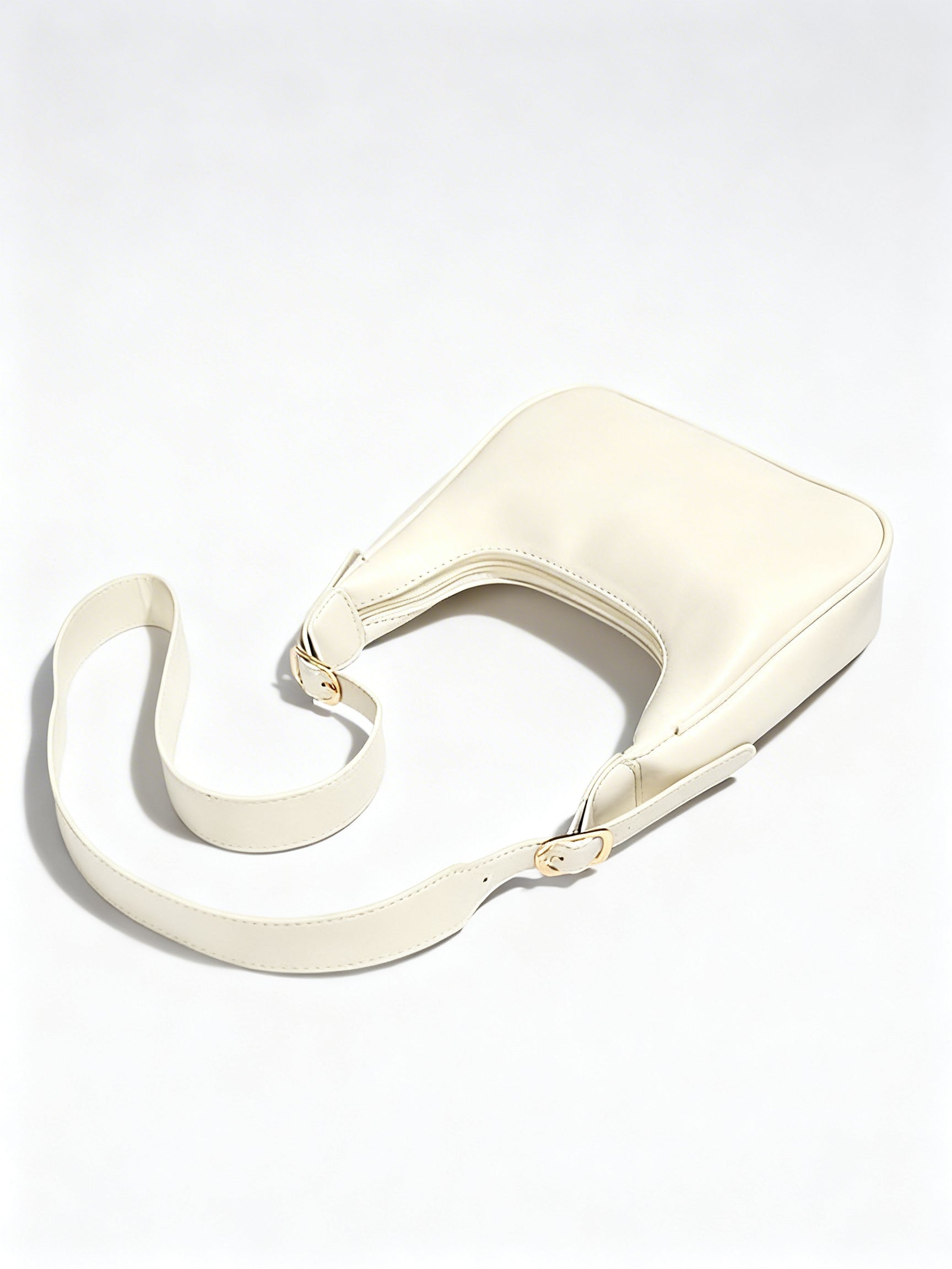 Vue de profil du sac bandoulière Croissant en cuir PU premium ivoire.