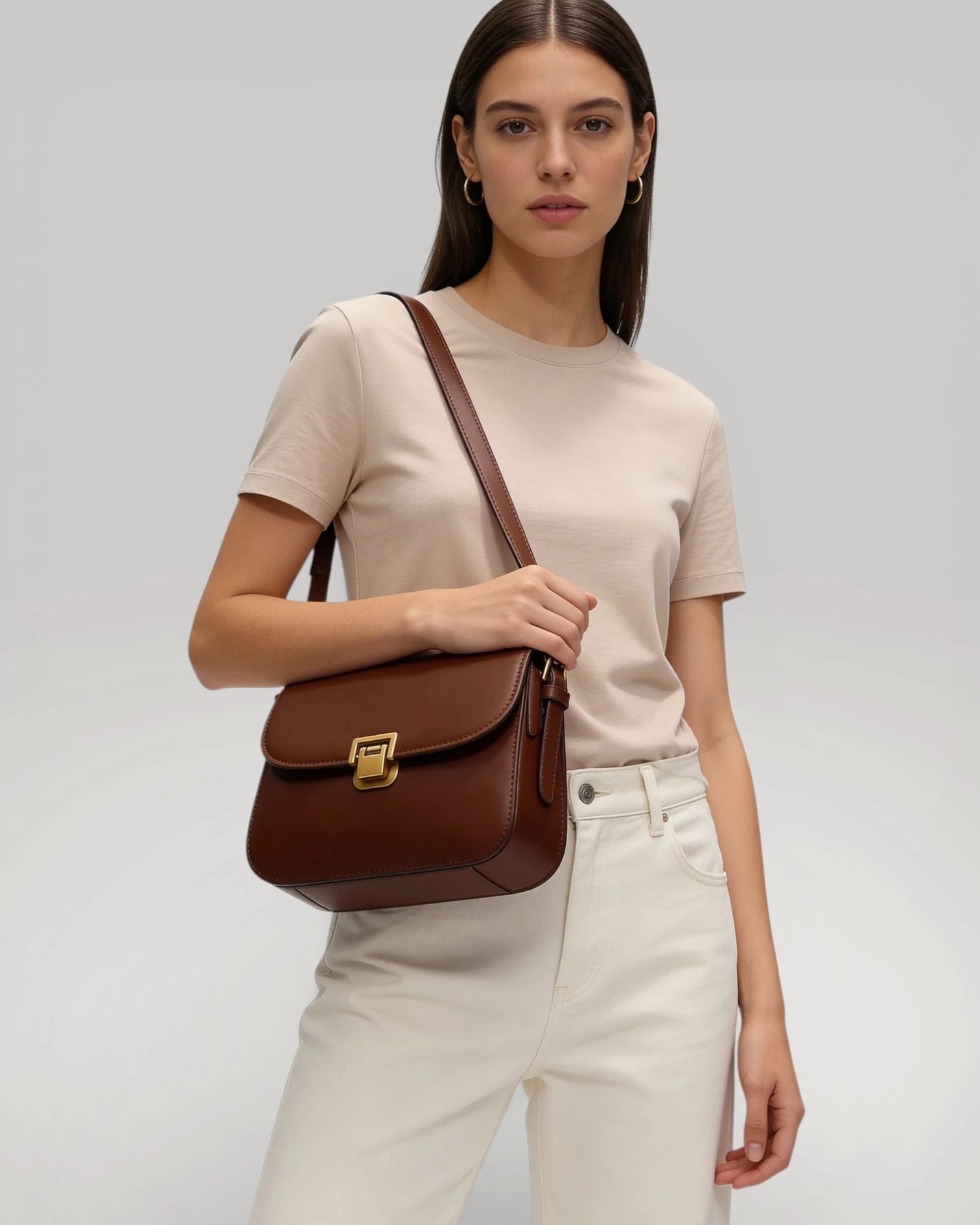 Femme portant le sac Vendôme marron en bandoulière style chic parisien.