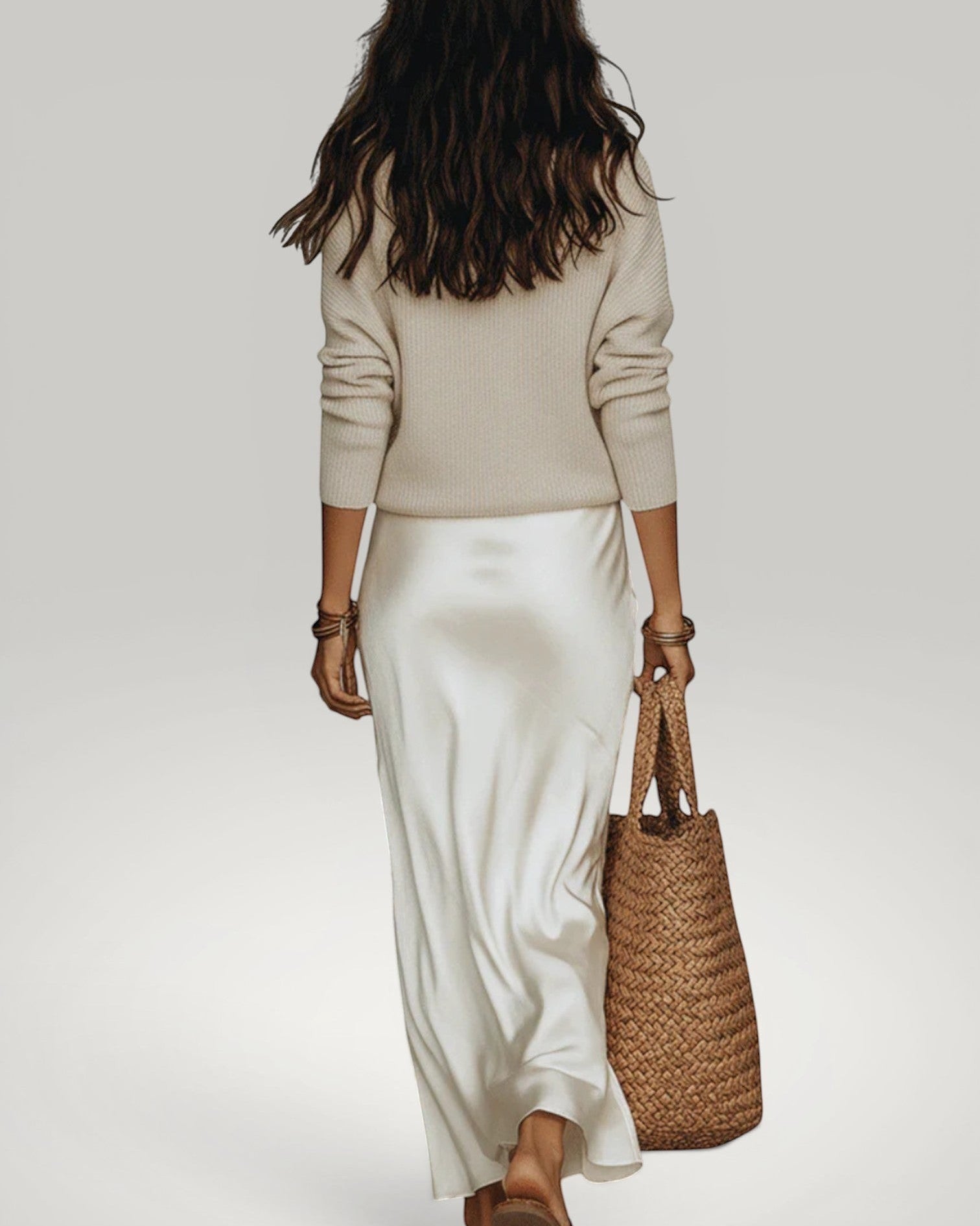 Urbain Couture Amélie satijnen midi-jurk met gebreide trui in crème, model draagt de outfit met een rieten tas.