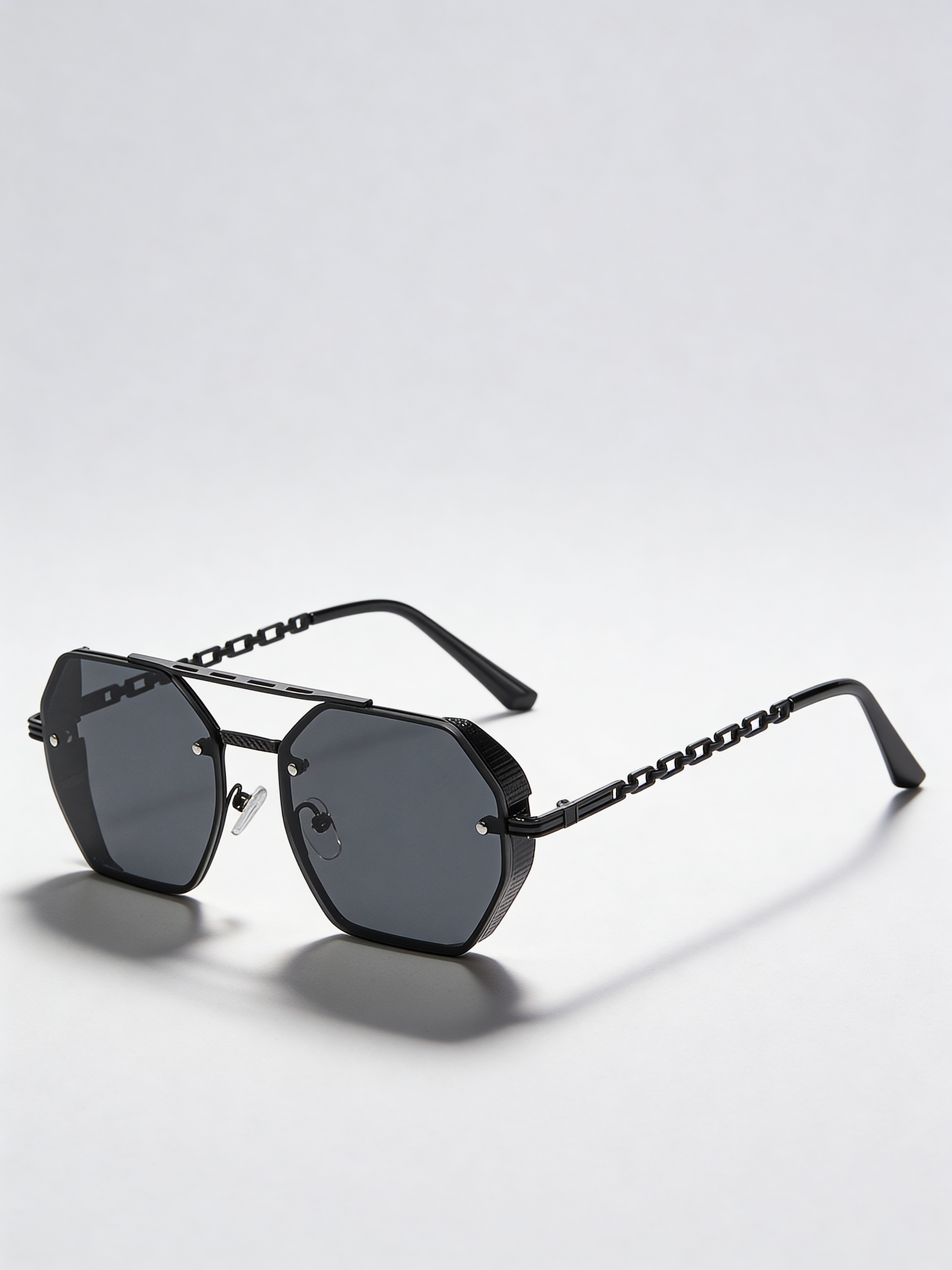 Lunettes de soleil unisexes avec chaîne dorée et verres noir fumé, style mystérieux et élégance parisienne.