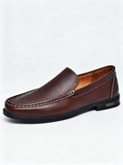 Soulier mocassin homme en cuir marron châtaigne avec détails de couture blancs.