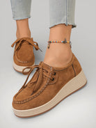 Femme portant des mocassins en suède couleur Terre de Sienne avec plateforme.