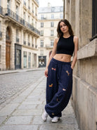 Femme portant le pantalon de jogging oversize bleu marine avec broderie teckel dans une rue de Paris - Style streetwear décontracté Urbain Couture