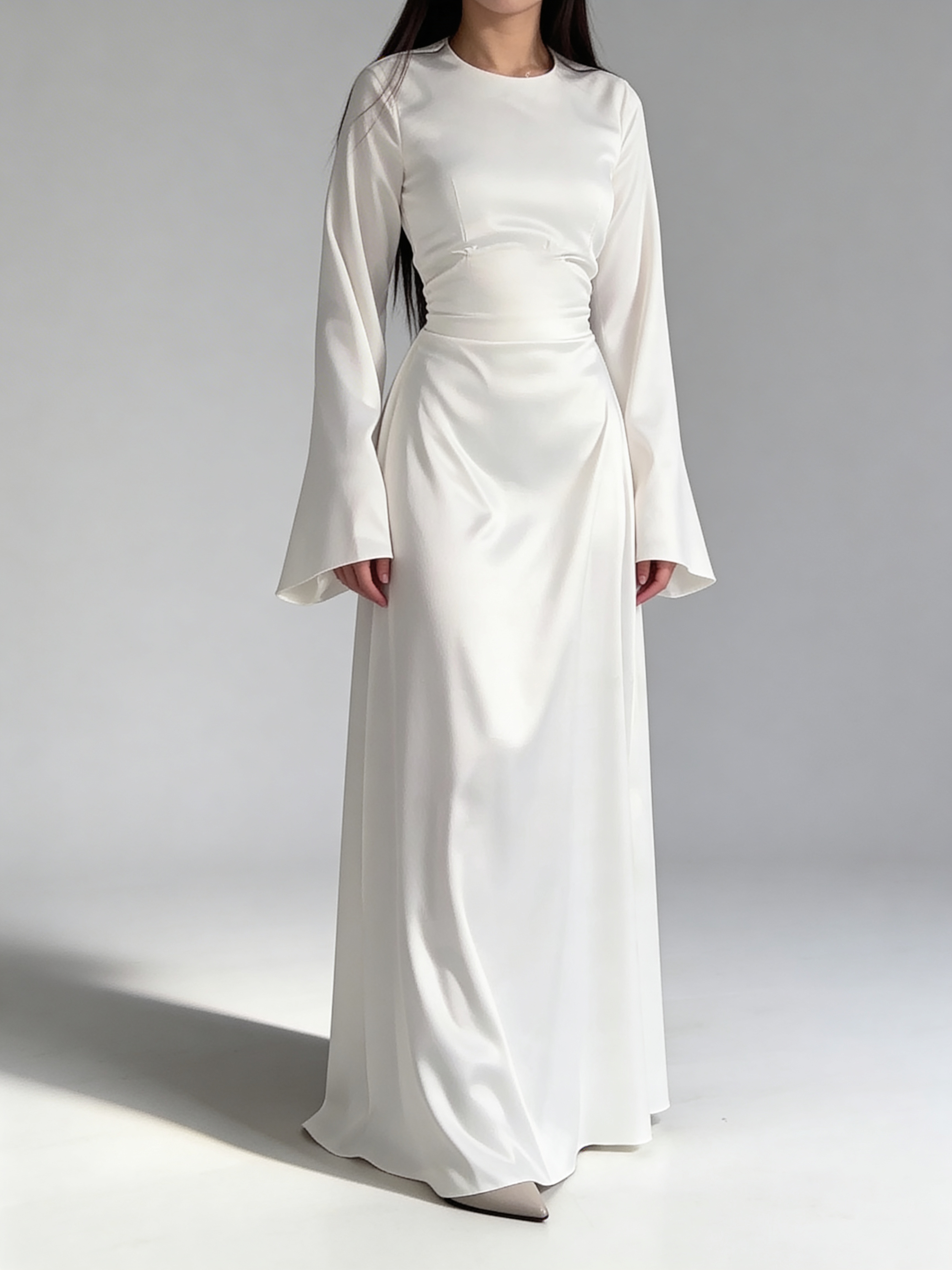 Femme portant la robe longue fluide en satin blanc, style chic et minimaliste.