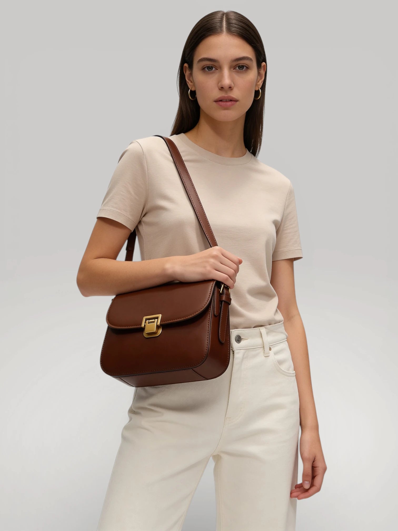 Femme portant le sac Vendôme marron en bandoulière style chic parisien.