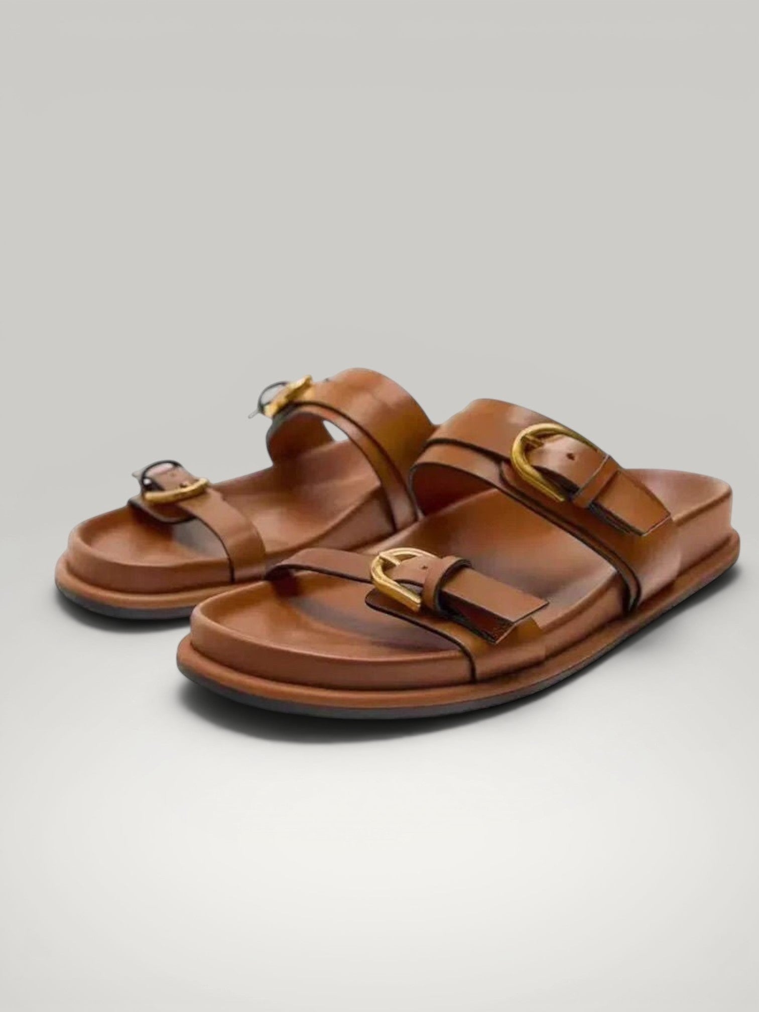 Urbain Couture Riviera minimalist leather sandals in brown with double gold buckles and adjustable straps.