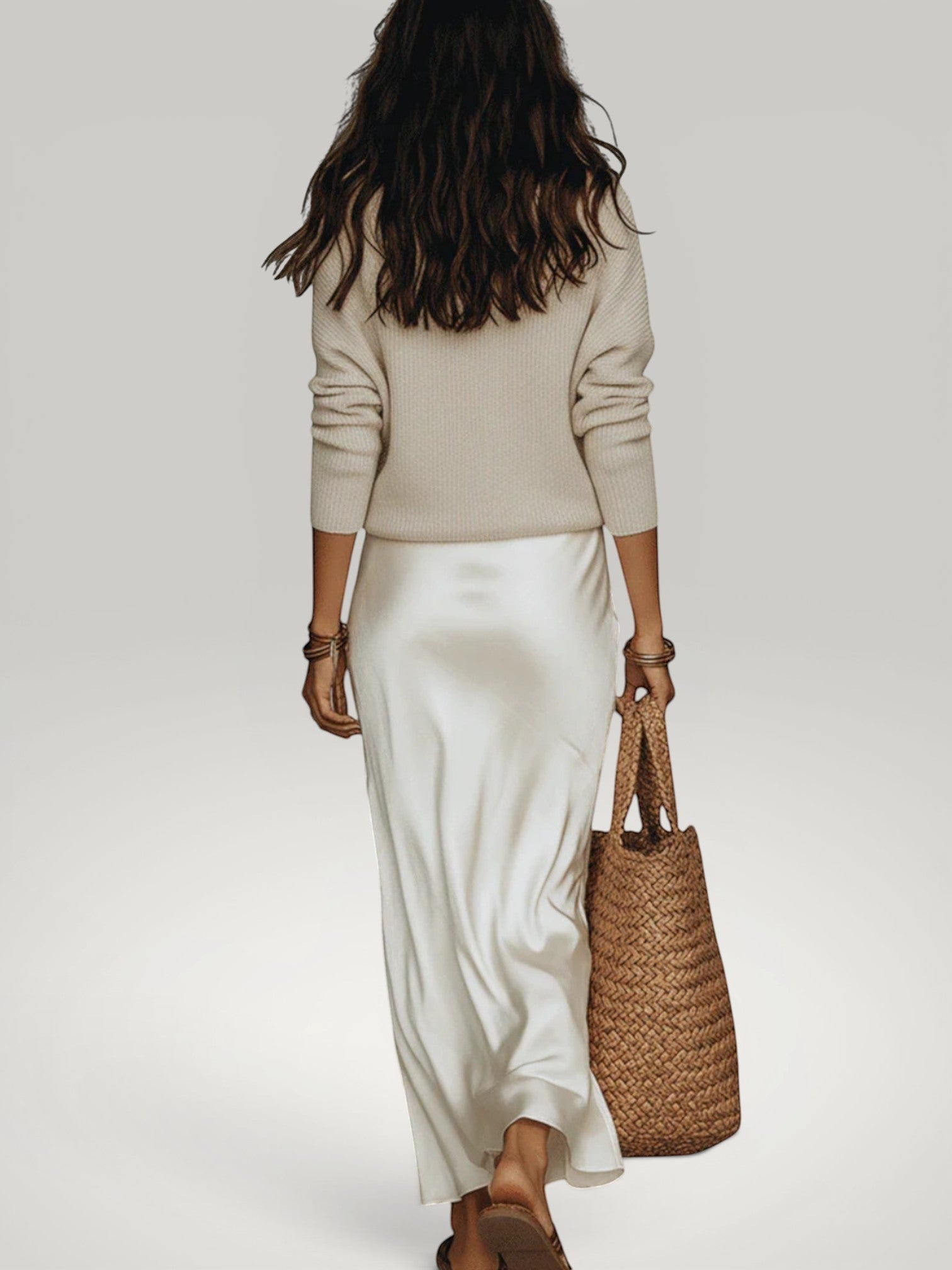 Urbain Couture Amélie satijnen midi-jurk met gebreide trui in crème, model draagt de outfit met een rieten tas.